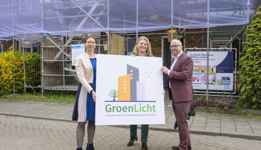 Drie personen staan met een foambord in hun handen waar het logo van project GroenLicht op staat.