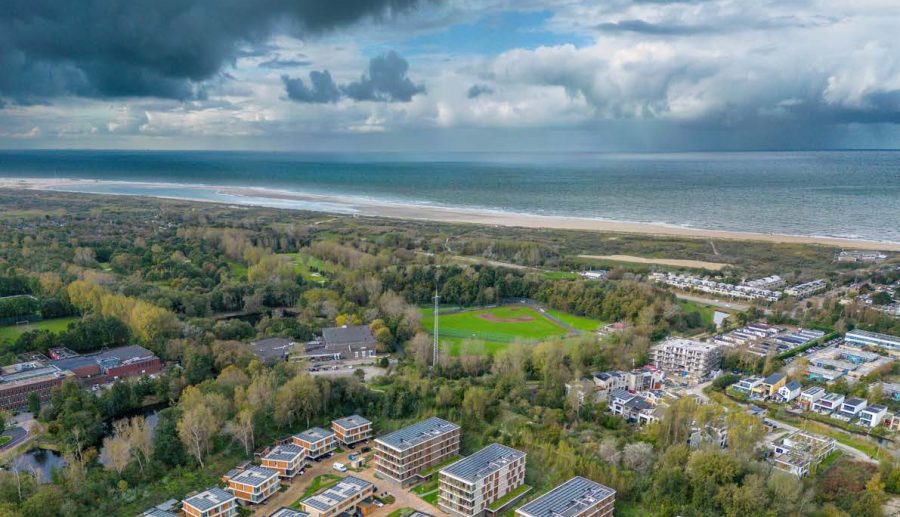 Dronefoto met verschillende gebouwen in een bosrijk gebied.